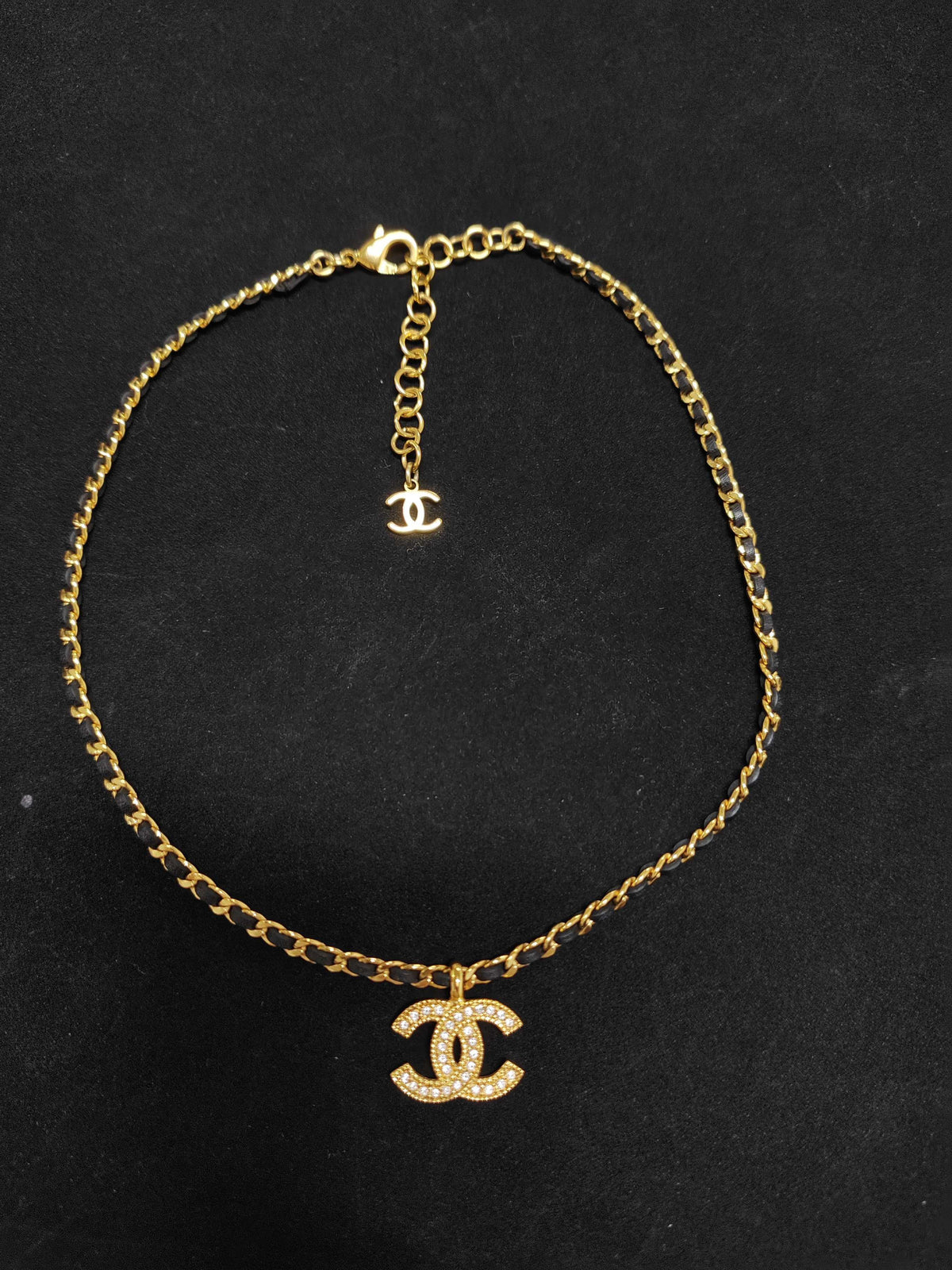 Chanel - Other - Gold-tone metal with rhinestone details and black leather interwoven through the chain. - Gold