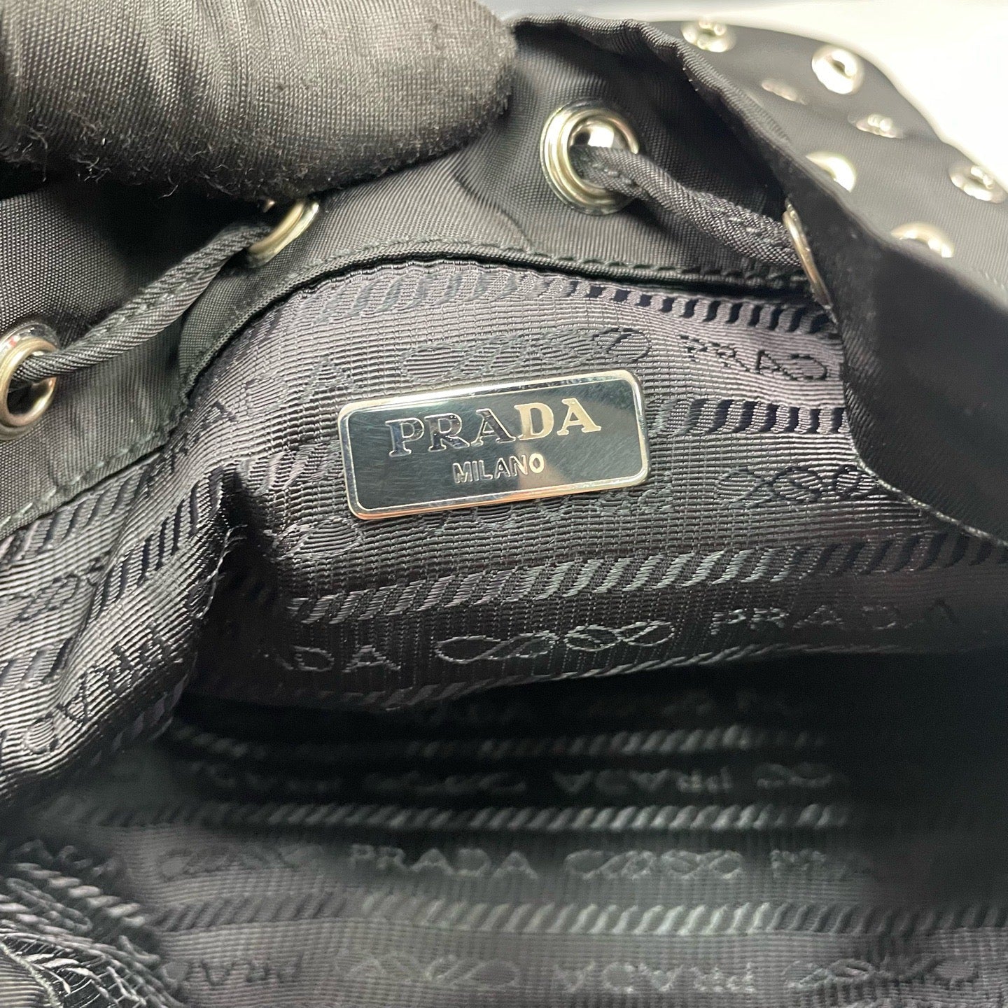 Prada - Grommet Embellished Drawstring Bucket Bag - Nylon fabric with leather trim - Black - (small)