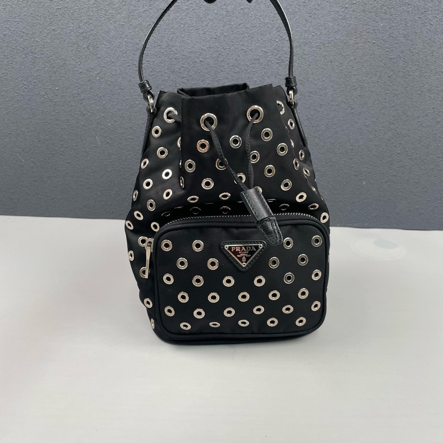 Prada - Grommet Embellished Drawstring Bucket Bag - Nylon fabric with leather trim - Black - (small)