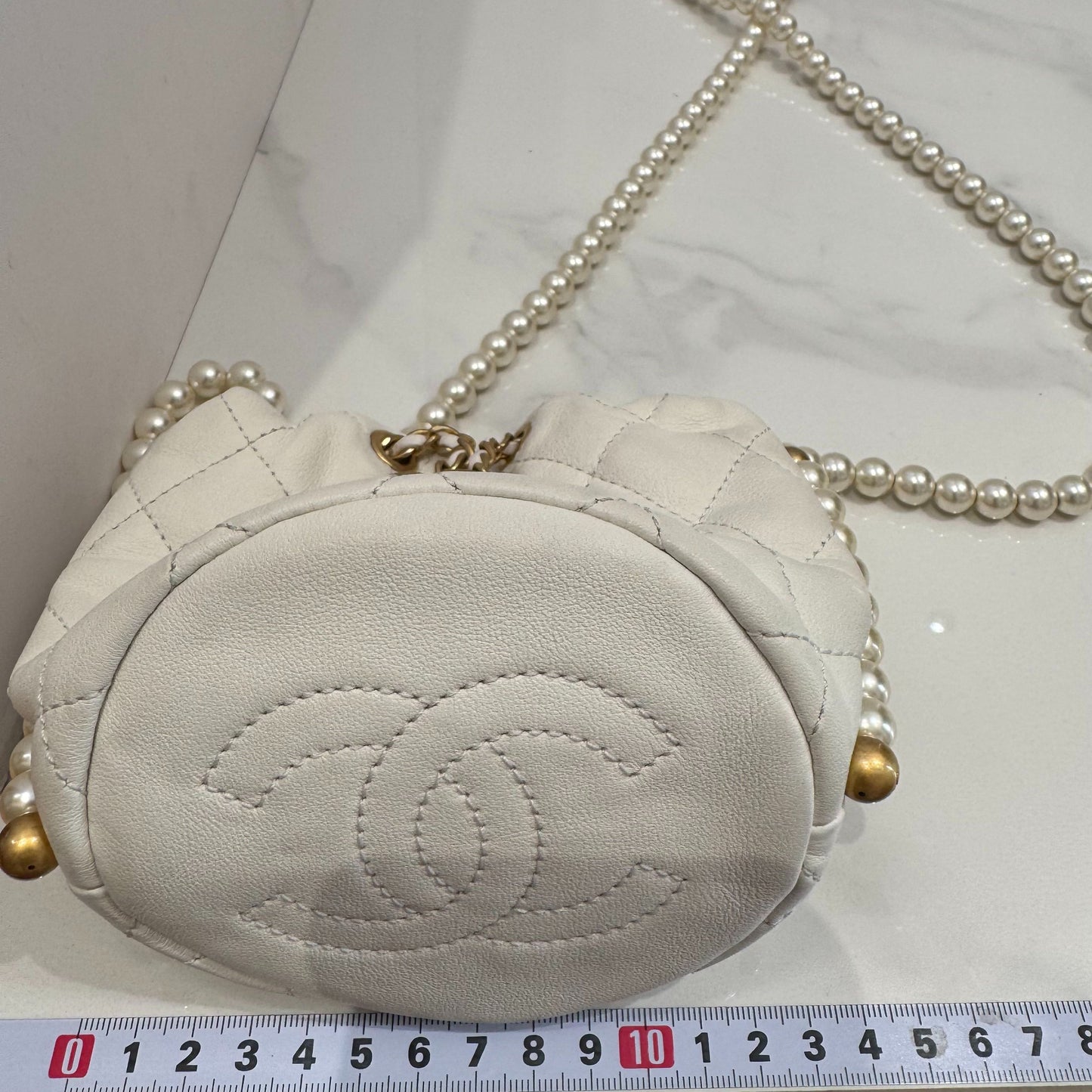 Chanel - 21S Pearl Mini Drawstring Bucket Bag - Lambskin leather and faux pearls - White with Gold-Tone Hardware - (Mini)