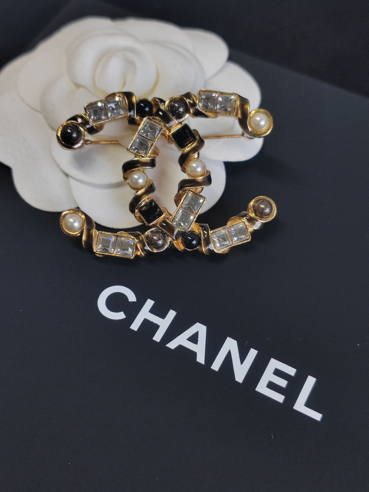 Chanel - Other - Gold-tone base metal with pearl, clear rhinestone or crystal, and black stone-like accents; exact stone and pearl composition is unspecified. - Multicolour