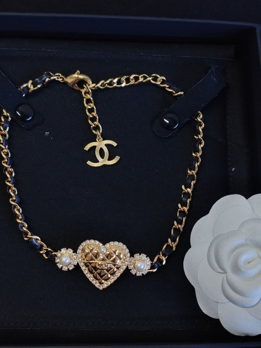Chanel - Other - Gold-tone base metal with rhinestones and pearl accents; black leather woven through the chain. - Gold