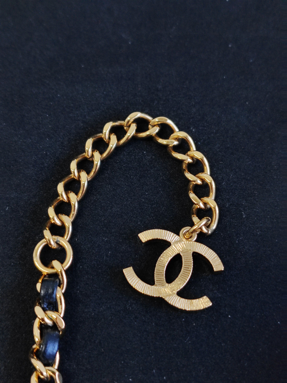 Chanel - Other - Gold-tone base metal with rhinestones and pearl accents; black leather woven through the chain. - Gold