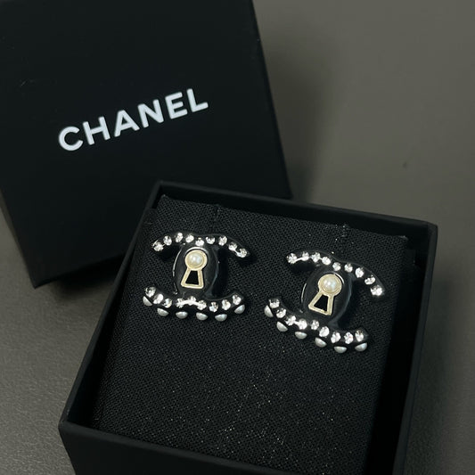 Chanel - Other - Gold-tone metal details with rhinestones, pearl and black resin elements; exact composition not confirmed. - Black