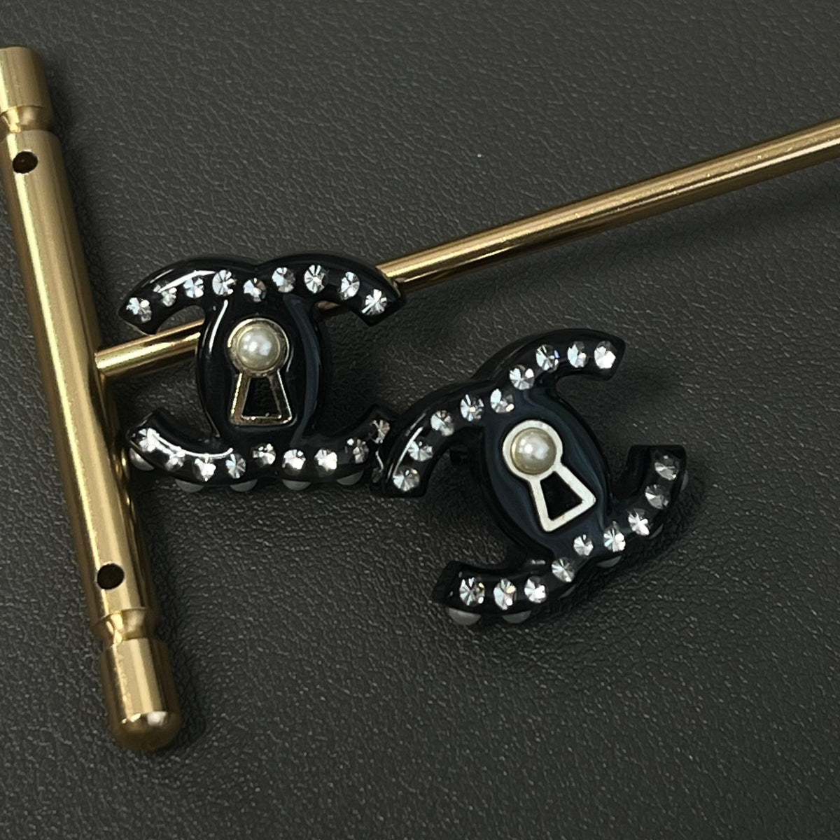 Chanel - Other - Gold-tone metal details with rhinestones, pearl and black resin elements; exact composition not confirmed. - Black