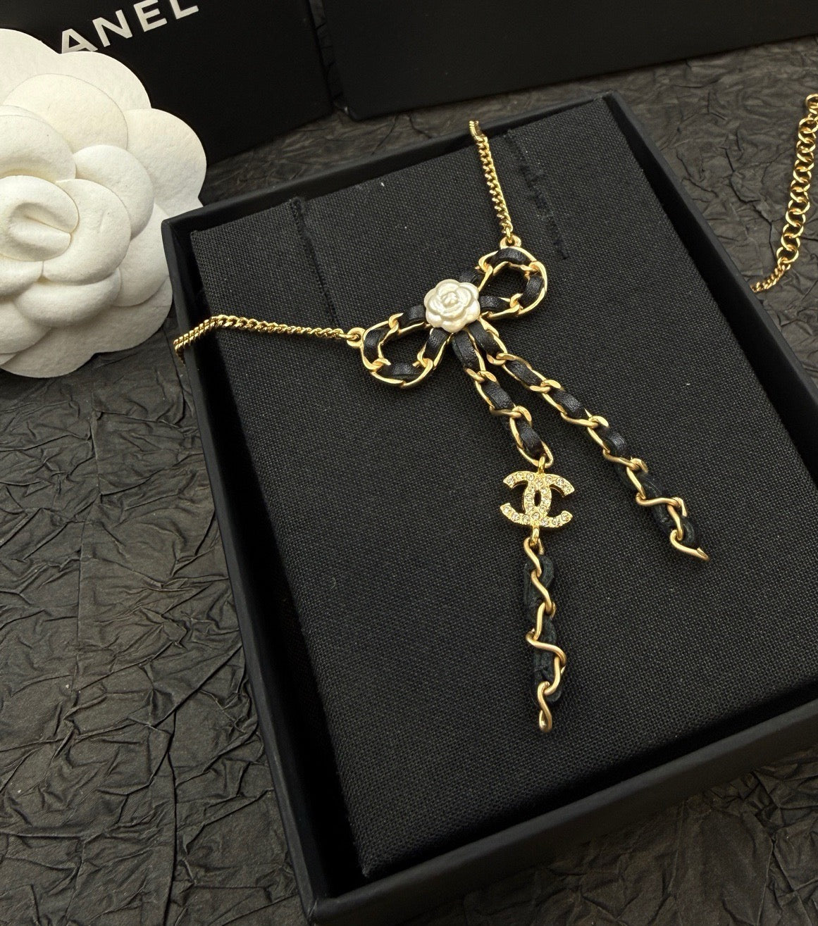 Chanel - Other - Gold-tone metal with black leather-interwoven elements and a white flower detail. - Multicolour - (39 cm necklace length; 15 cm extension chain)