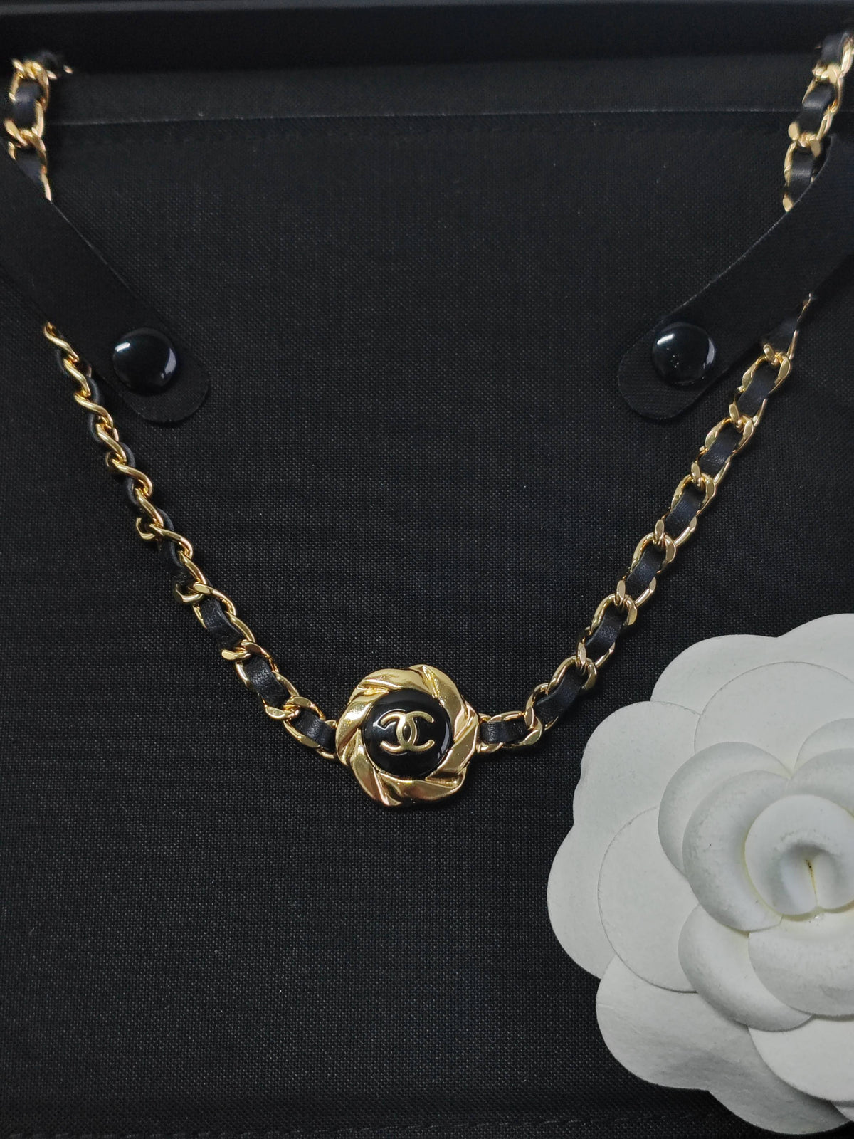 Chanel - Other - Gold-tone metal with black leather woven through the chain and a black centre detail. - Black