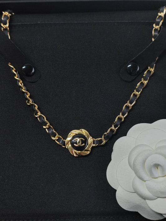 Chanel - Other - Gold-tone metal with black leather woven through the chain and a black centre detail. - Black