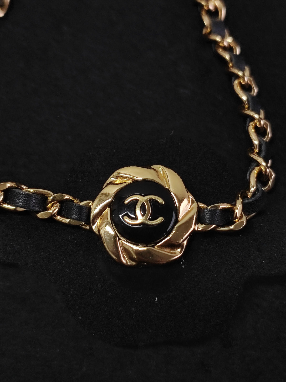 Chanel - Other - Gold-tone metal with black leather woven through the chain and a black centre detail. - Black