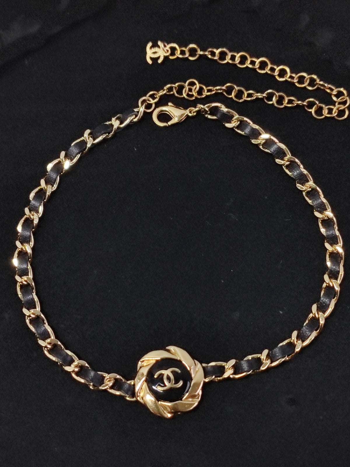 Chanel - Other - Gold-tone metal with black leather woven through the chain and a black centre detail. - Black