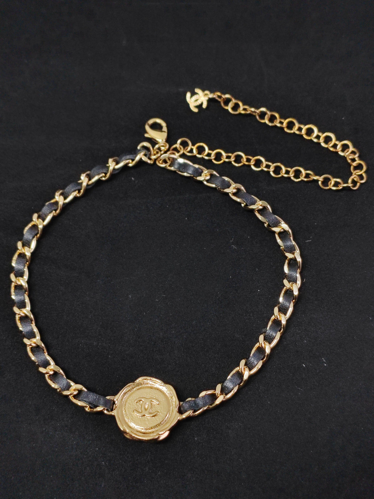 Chanel - Other - Gold-tone metal with black leather woven through the chain and a black centre detail. - Black