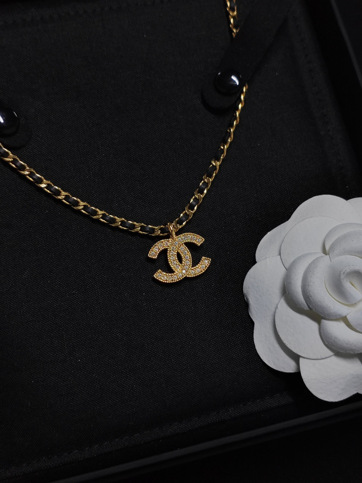 Chanel - Other - Gold-tone metal with rhinestone details and black leather interwoven through the chain. - Gold