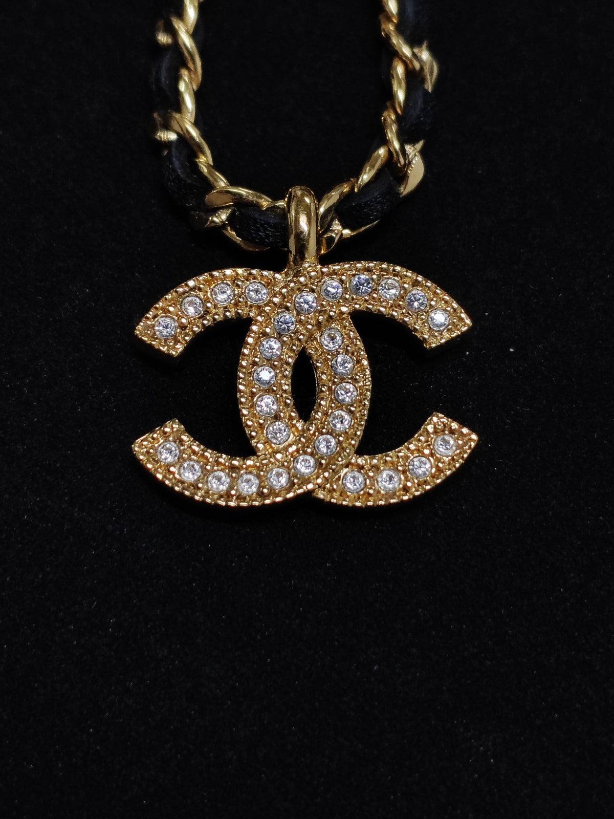 Chanel - Other - Gold-tone metal with rhinestone details and black leather interwoven through the chain. - Gold
