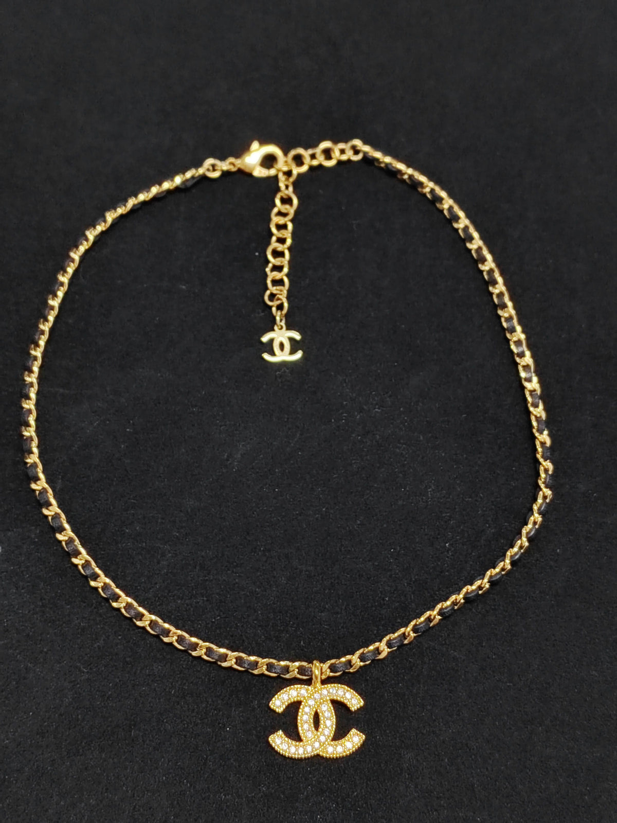 Chanel - Other - Gold-tone metal with rhinestone details and black leather interwoven through the chain. - Gold