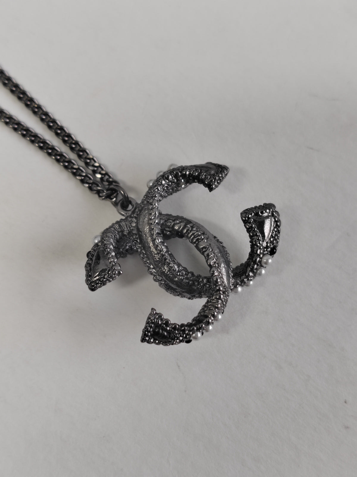 Chanel - Other - Silver-tone base metal with pearl-like and dark decorative accents; exact composition is not confirmed. - Silver