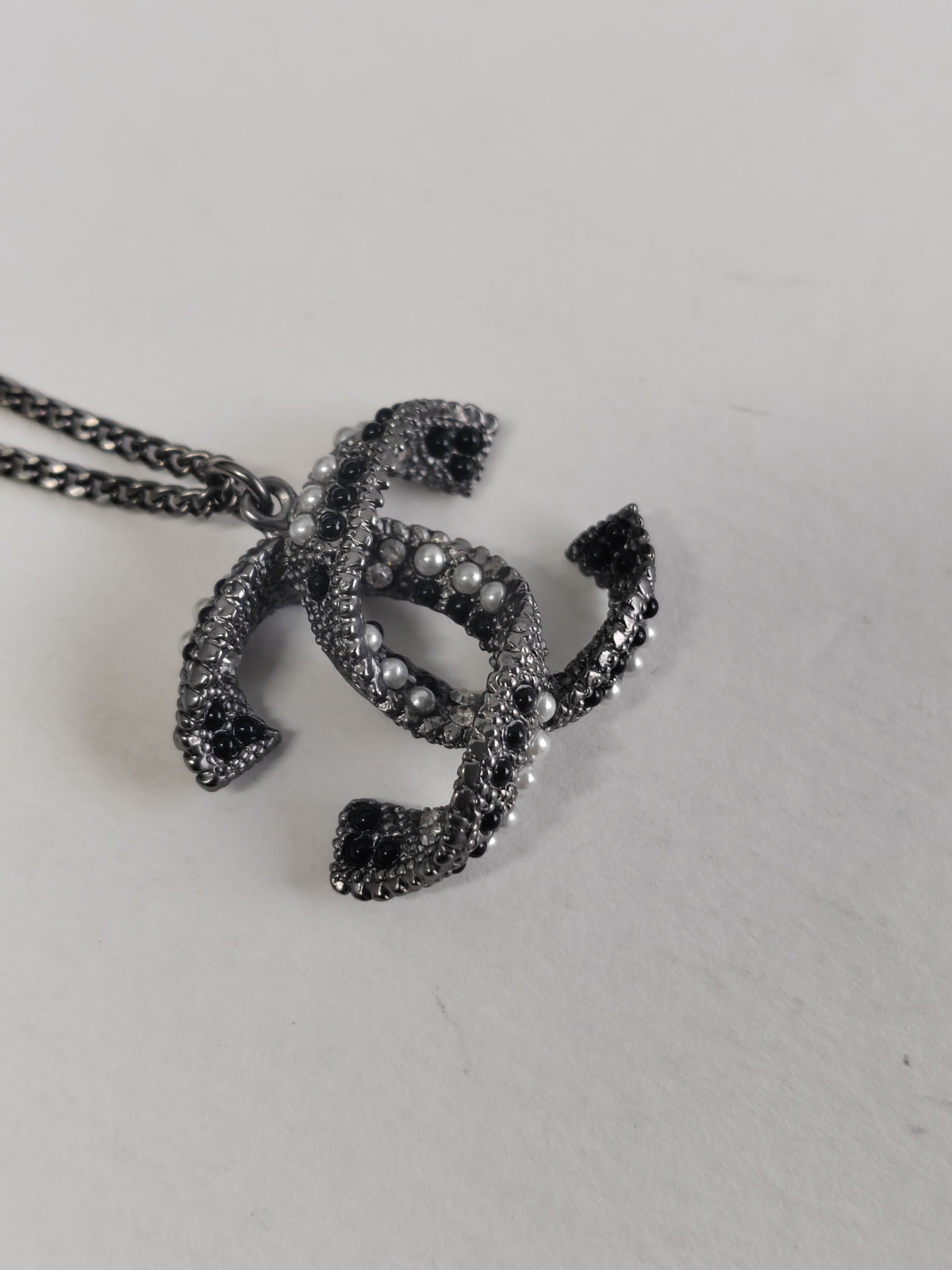 Chanel - Other - Silver-tone base metal with pearl-like and dark decorative accents; exact composition is not confirmed. - Silver