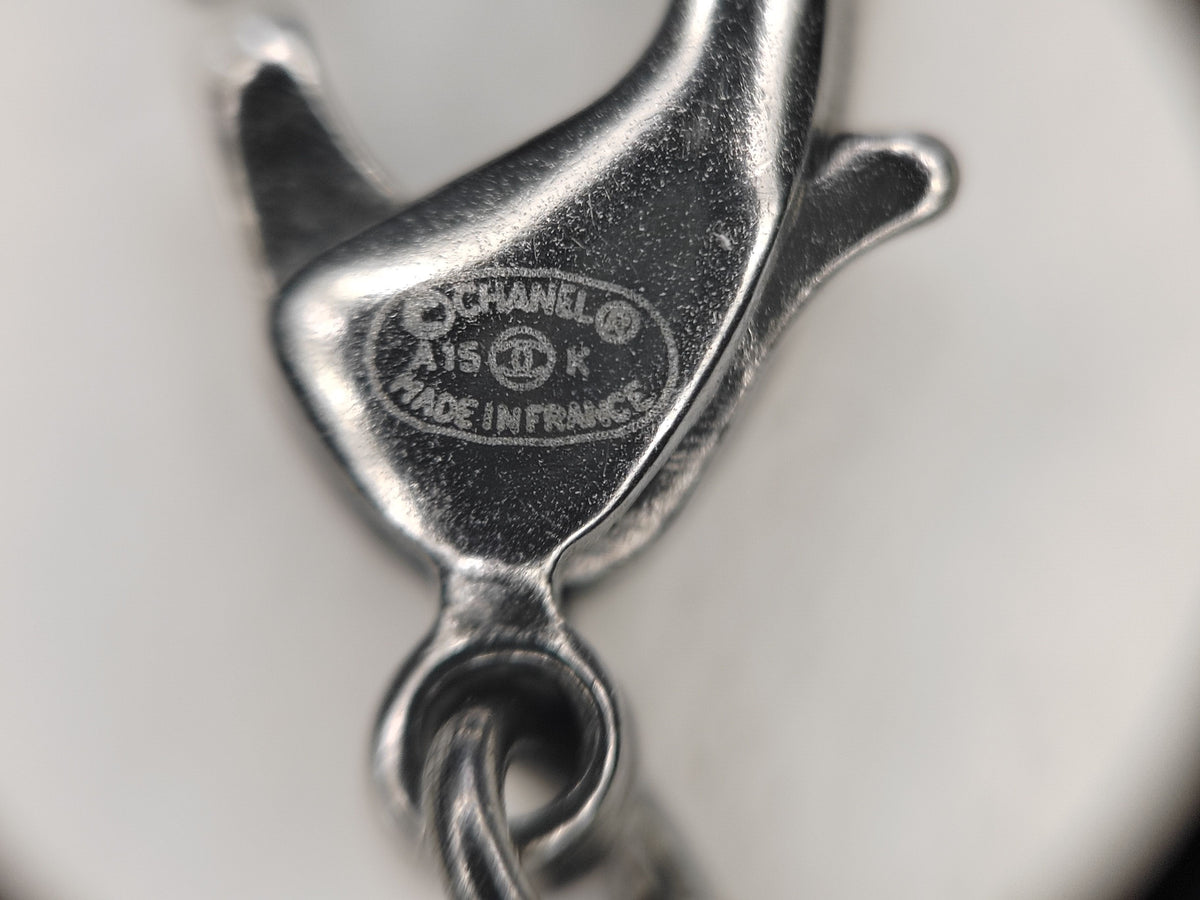 Chanel - Other - Silver-tone base metal with pearl-like and dark decorative accents; exact composition is not confirmed. - Silver