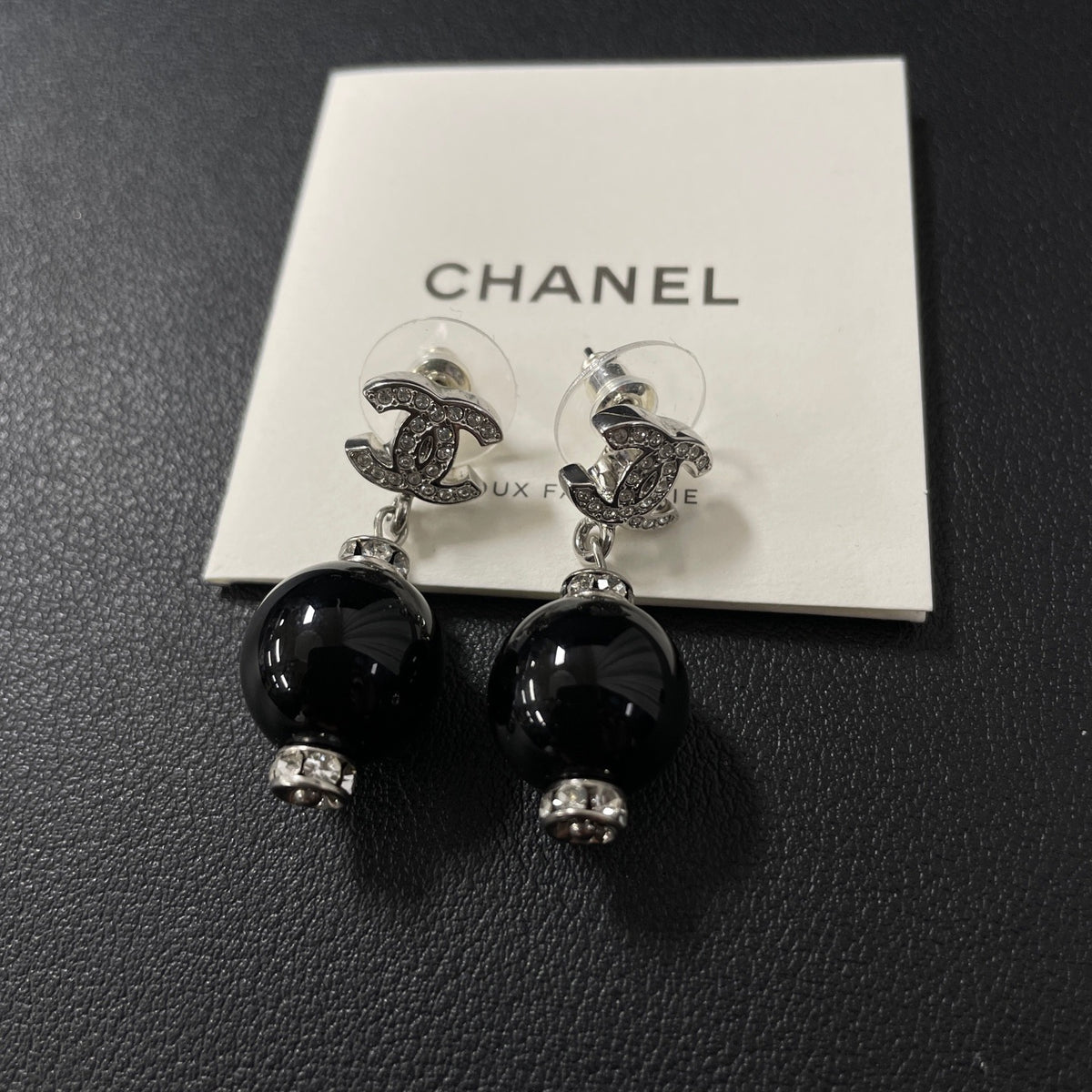 Chanel - Other - Silver-tone costume-jewellery metal with clear rhinestone accents and glossy black bead drops; exact stone and bead compositions are unconfirmed. - Multicolour