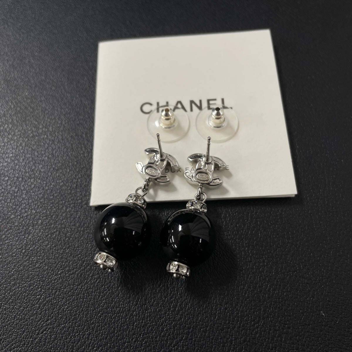 Chanel - Other - Silver-tone costume-jewellery metal with clear rhinestone accents and glossy black bead drops; exact stone and bead compositions are unconfirmed. - Multicolour