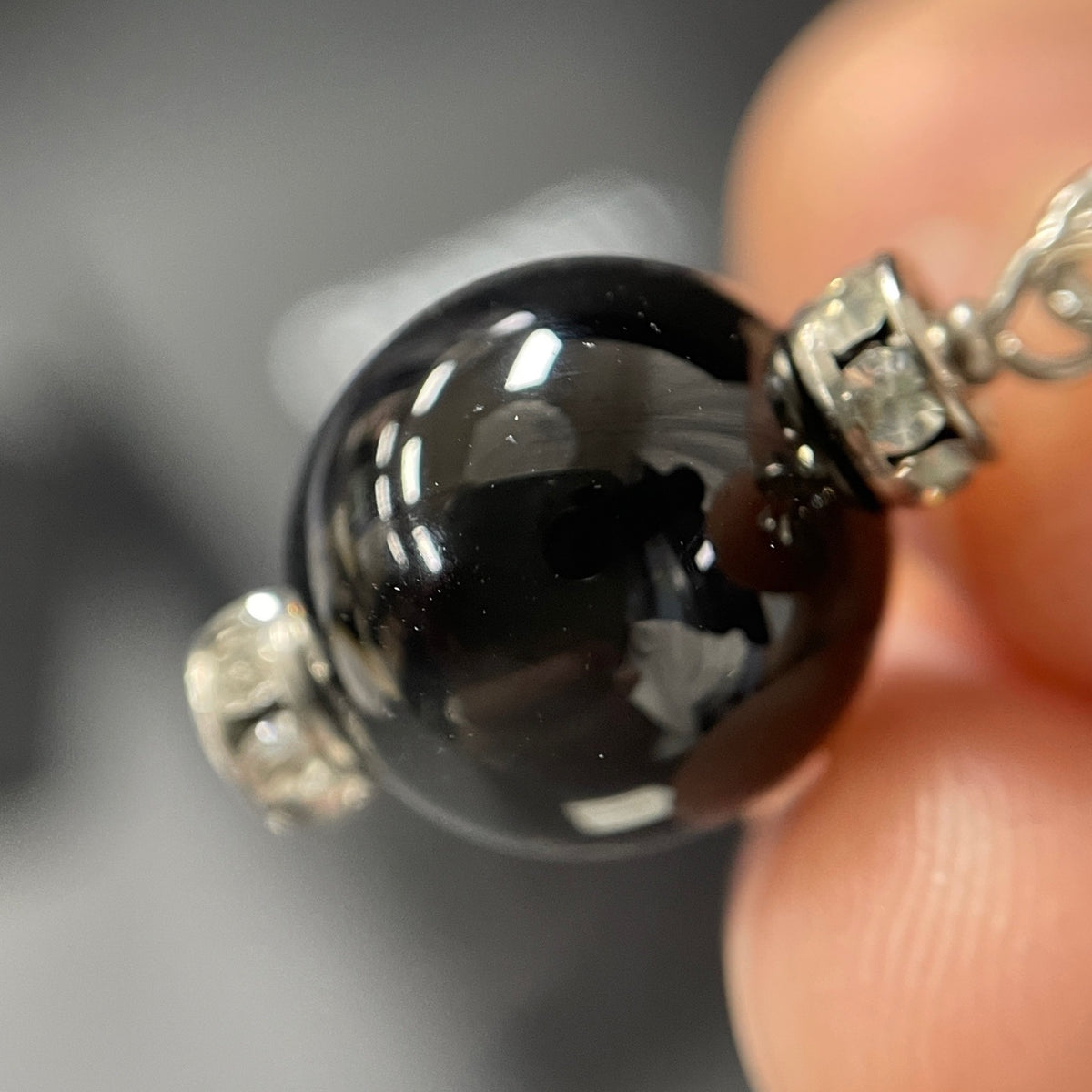 Chanel - Other - Silver-tone costume-jewellery metal with clear rhinestone accents and glossy black bead drops; exact stone and bead compositions are unconfirmed. - Multicolour