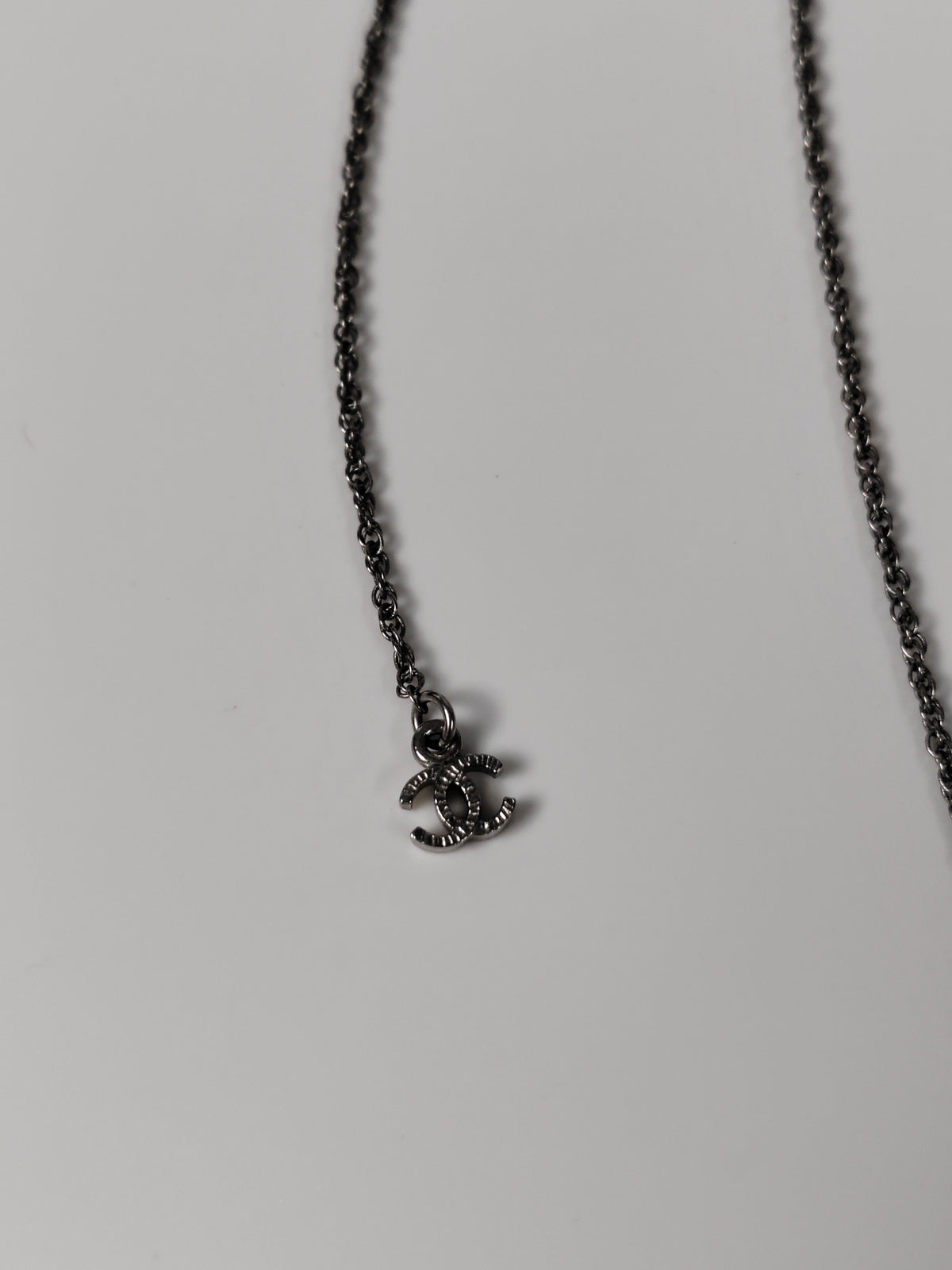 Chanel - Other - Silver-tone metal alloy with clear rhinestone accents and dark round decorative beads. - Silver
