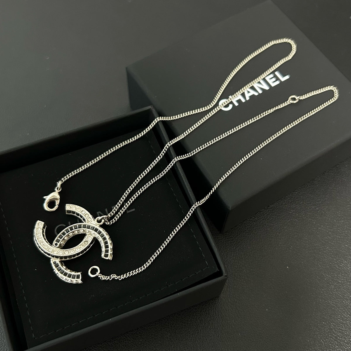 Chanel - Other - Silver-tone metal with clear and black glass-like embellishments; exact stone composition is unconfirmed. - Silver