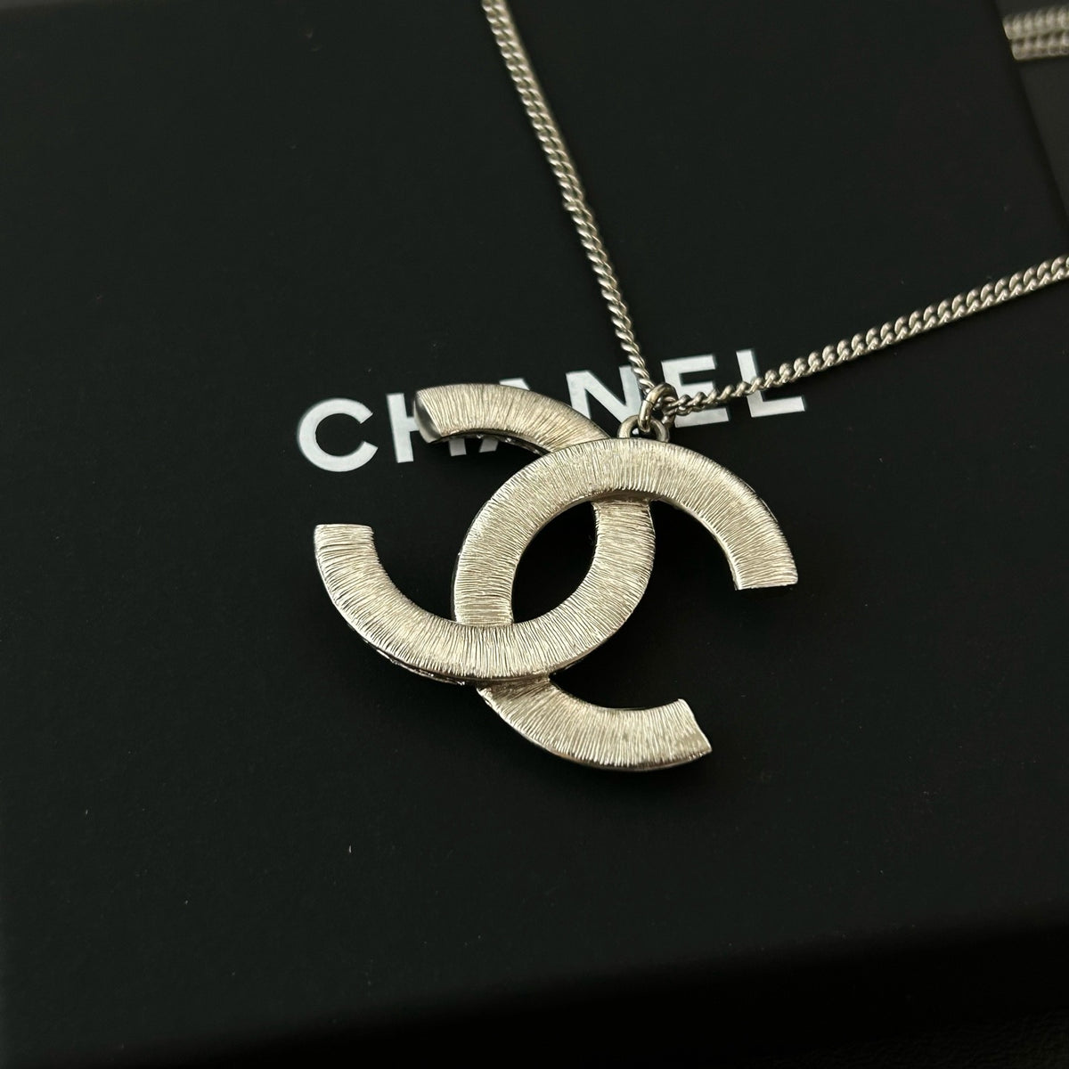 Chanel - Other - Silver-tone metal with clear and black glass-like embellishments; exact stone composition is unconfirmed. - Silver
