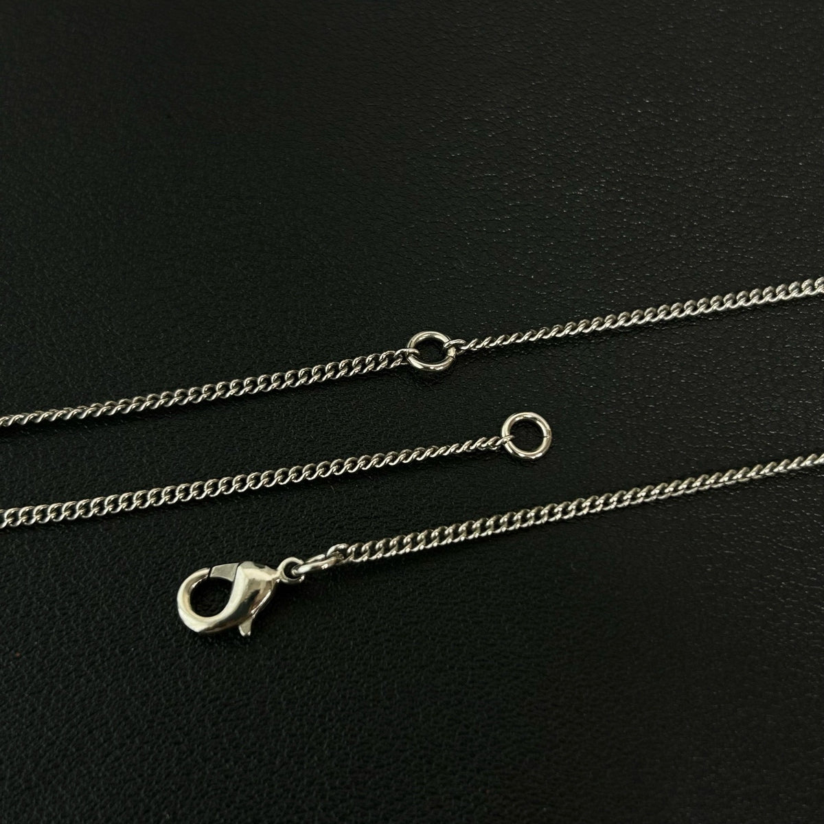 Chanel - Other - Silver-tone metal with clear and black glass-like embellishments; exact stone composition is unconfirmed. - Silver