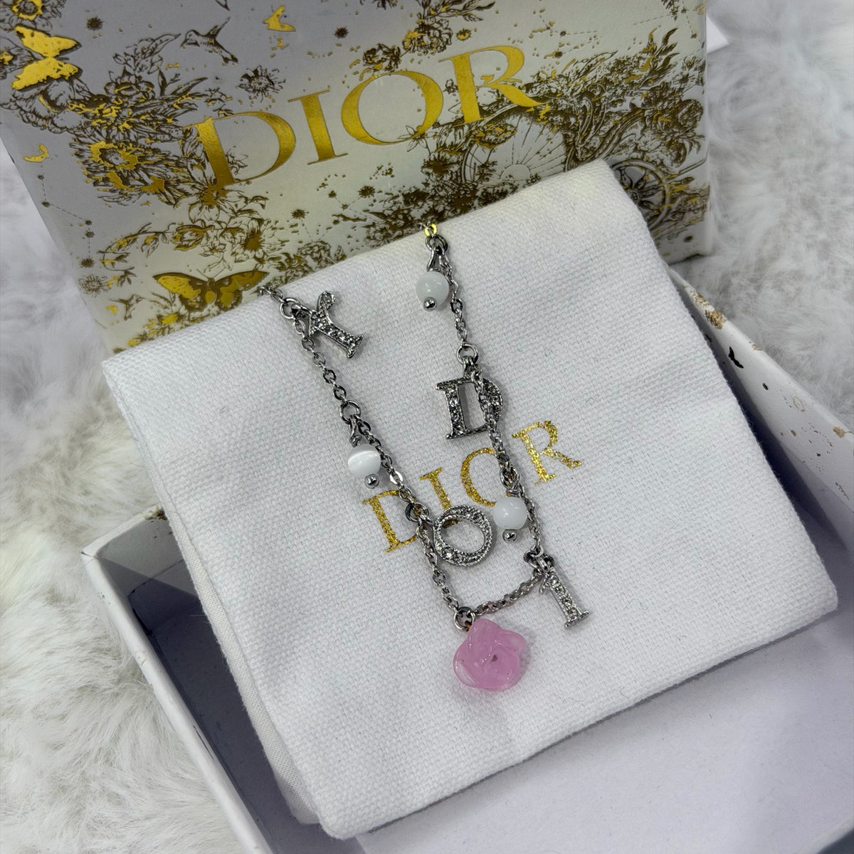 Dior - Other - Silver-tone metal chain and charms with decorative stones, white bead accents and a glass flower charm. - Multicolour