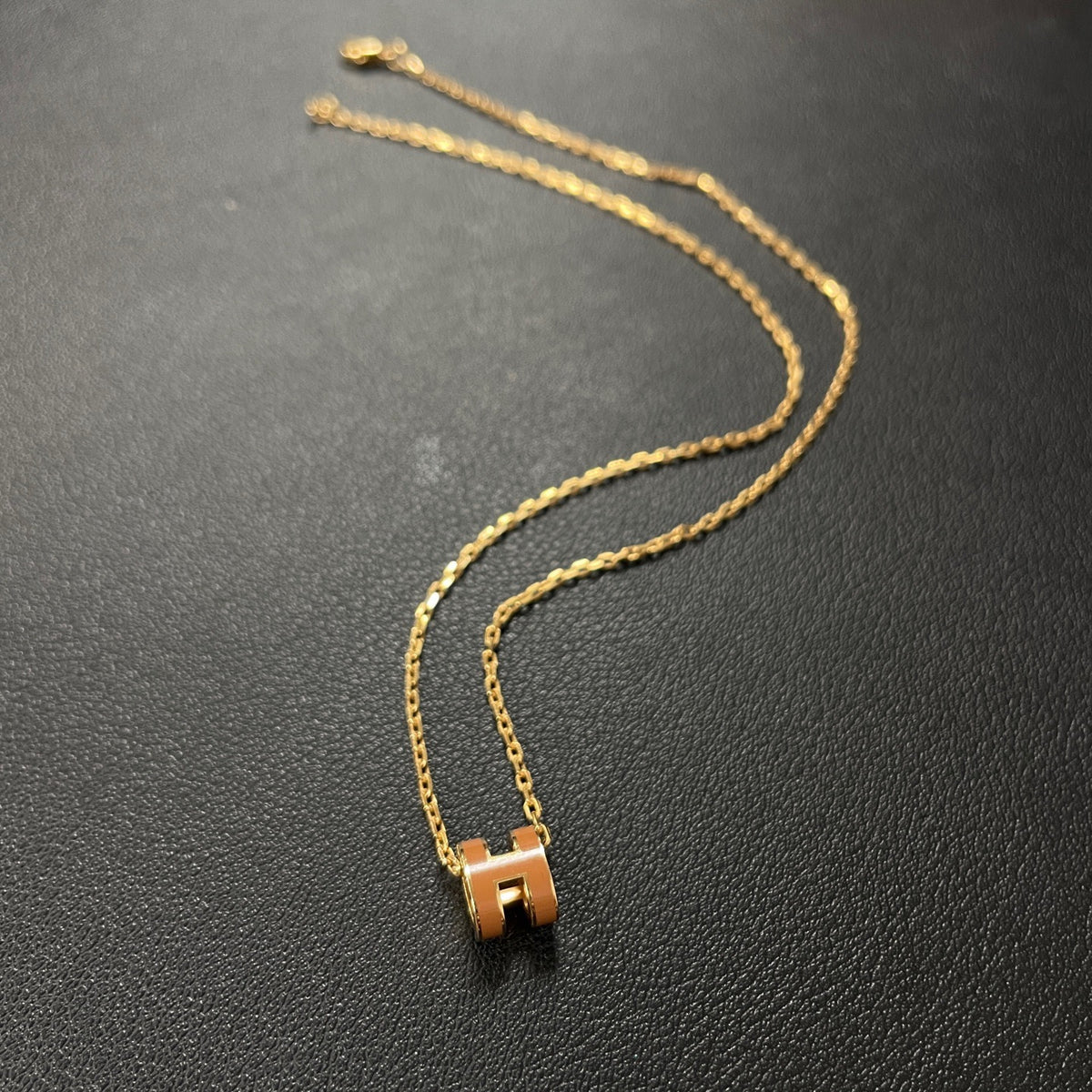 Hermes - Mini Pop H - Lacquered metal pendant with a rose-gold-tone metal chain; exact metal composition is not specified. - Orange