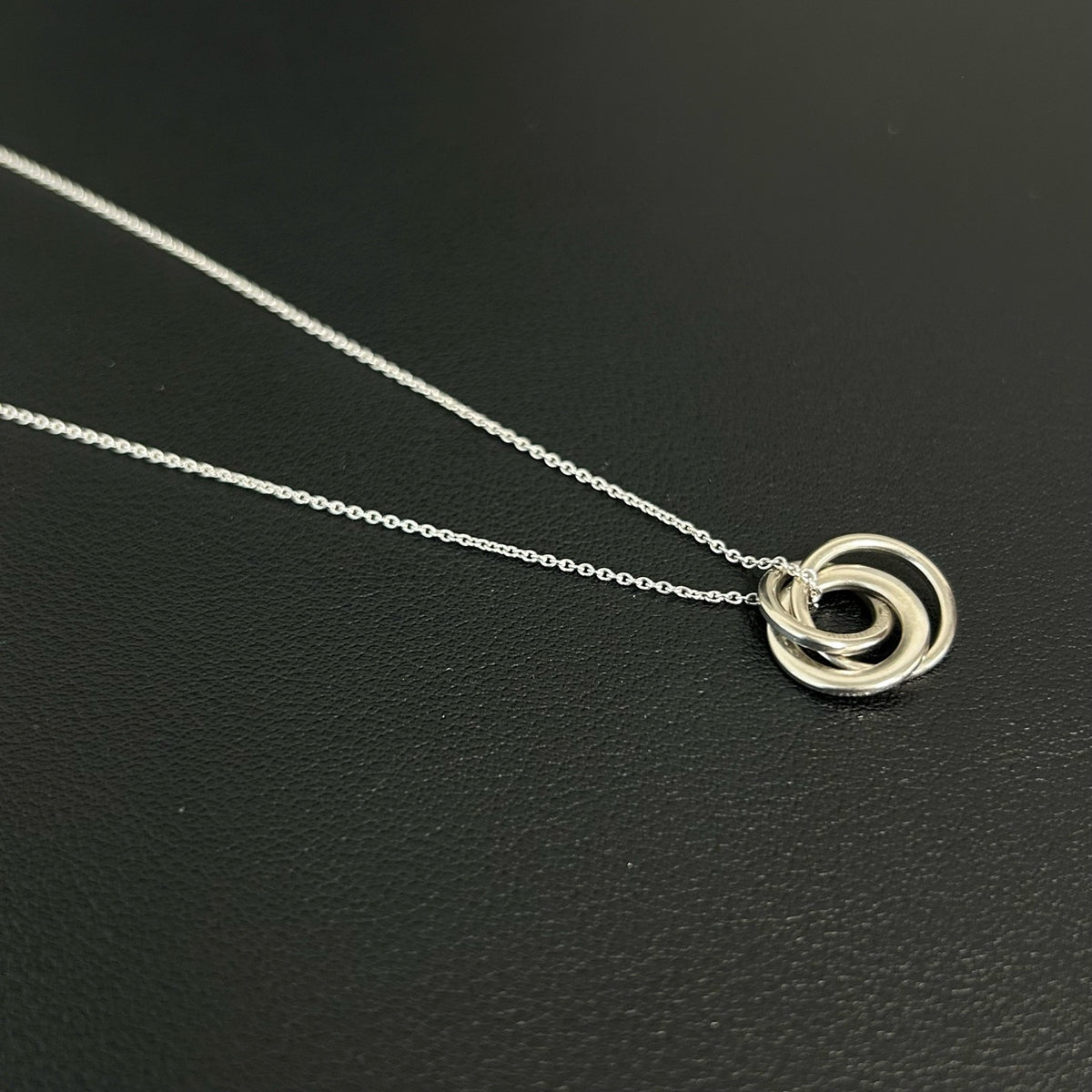 Tiffany & Co. - Interlocking Circles - Sterling silver; the pendant appears to bear a 925 hallmark. One circle is set with pave diamonds. - Silver